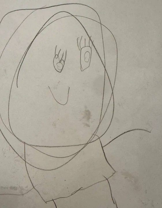 A child’s drawing of a girl with a giant round head and long hair