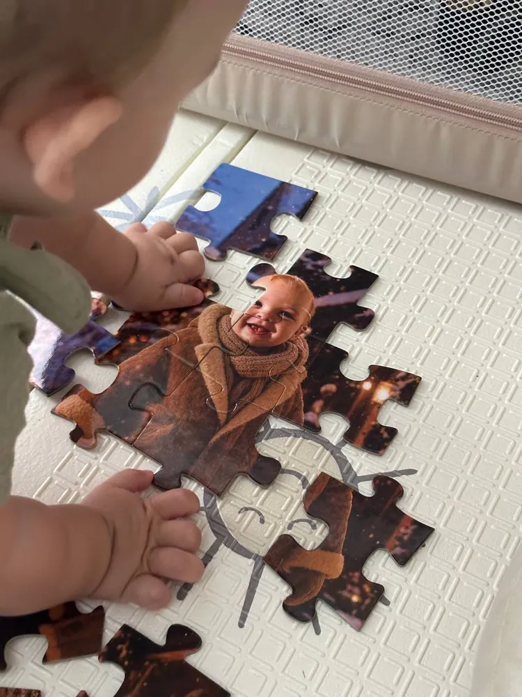 A close-up of a child’s hands placing the pieces of a custom winter portrait puzzle