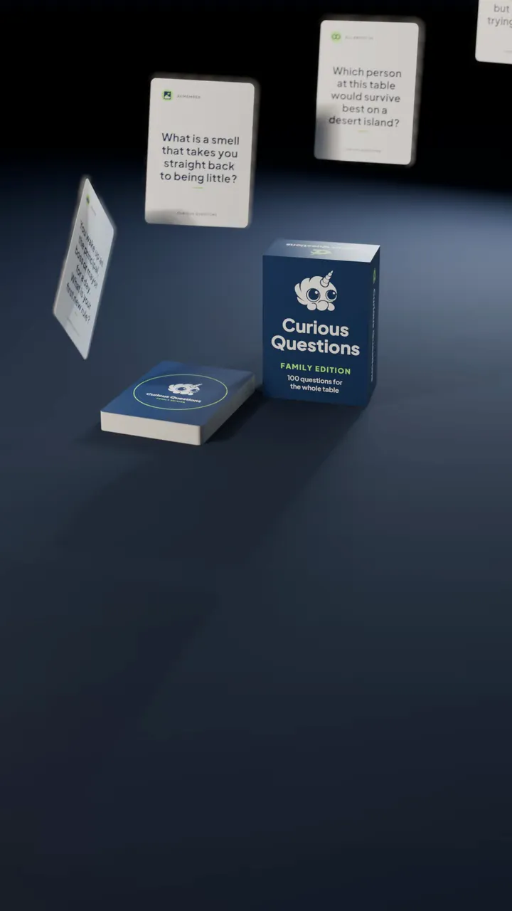 The Curious Questions box standing on a table beside its deck, with question cards lifting off the deck