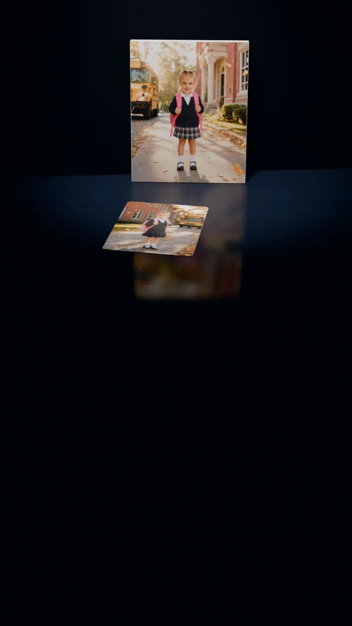 Two Back to School portraits in a dark room: one on a gallery canvas leaning against the wall, the other on a 30-piece puzzle in front of it, a piece lifting out of its slot, turning over and settling back